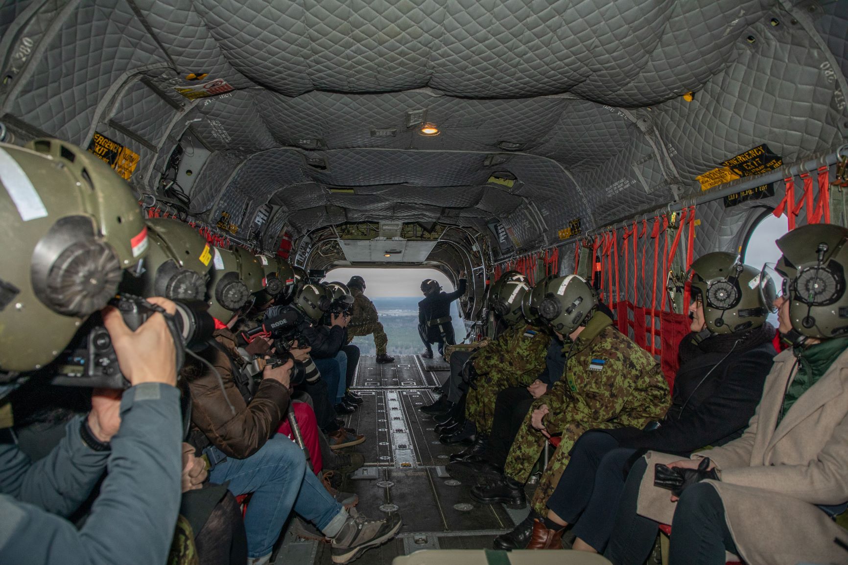 Image shows RAF aviators inside a Chinook, looking towards the open loading bay. 